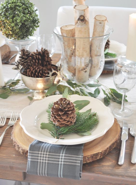 a gorgeous woodland table setting like this one will do for both Thanksgiving and Christmas, with its pinecones, evergreens and plaid napkins