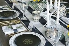 a lovely black and white Thanksgiving tablescape with a buffalo check runner, white candles, black plates and gold cutlery