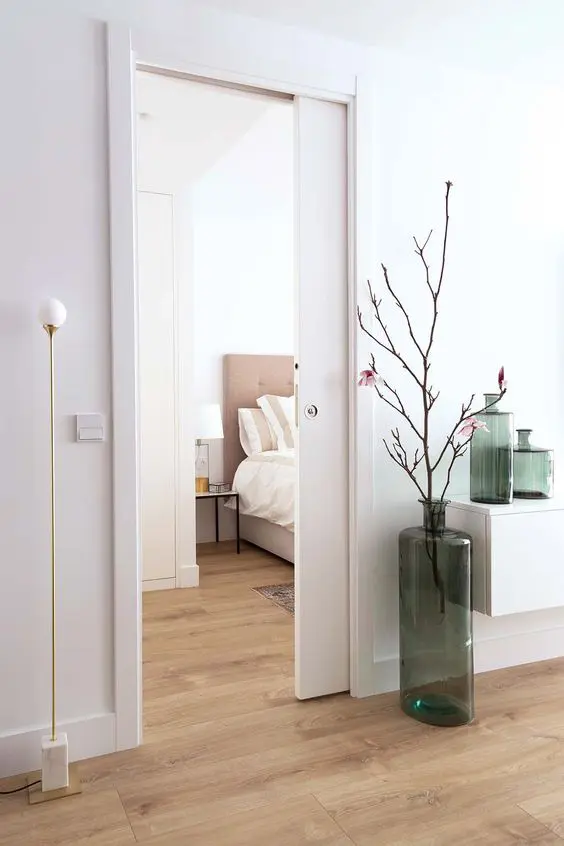 a neutral Scandinavian space with a single pocket door that separates the spaces without taking any additional space