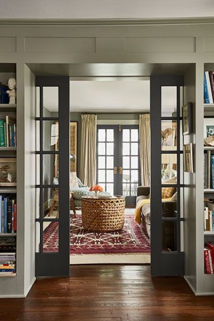 a welcoming farmhouse in a muted color scheme and with plenty of pattern, with grey French pocket doors is a very cool space