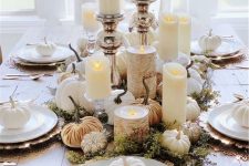 an elegant white Thanksgiving tablescape with beautiful chargers, white porcelain and pumpkins, pillar candles and orange velvet pumpkins