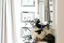 black and white Thanksgiving decor with pumpkins, berries, a butterfly and a bird is a cool idea