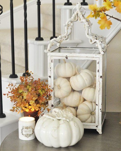 pretty neutral Thanksgiving decor with a vintage glass candle lantern filled with pumpkins and a vintage porcelain one is wow