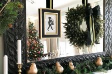 02 lovely black, gold and green Christmas decor with an evergreen garland with lights, gilded pears, an evergreen wreath with a black bow
