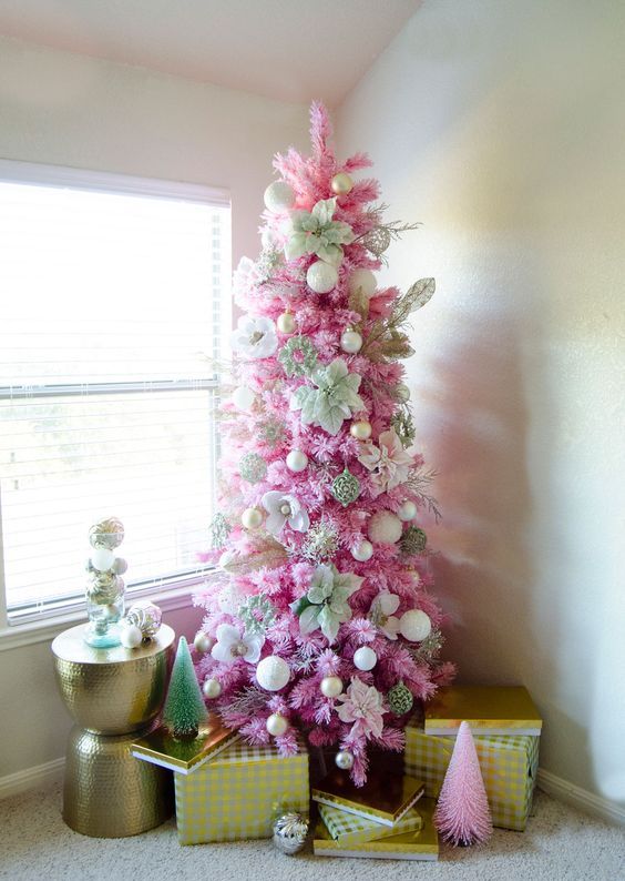 a bold pink Christmas tree with white and gold ornaments and oversized faux white blooms is a glam and shiny solution for your space