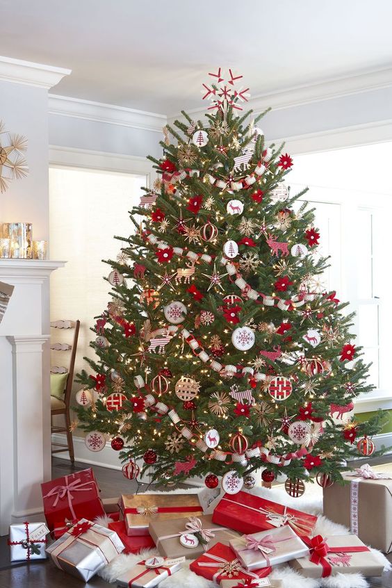 an impressive traditional Scandinavian Christmas tree with red and white ornaments and garlands is a gorgeous holiday statement