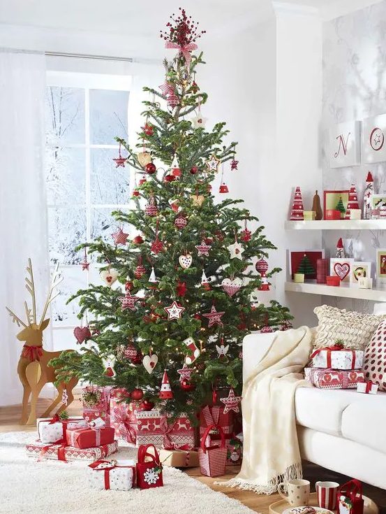 a traditional Scandinavian Christmas tree with various red and white ornaments and plaid decorations plus gifts wrapped with red and white printed paper