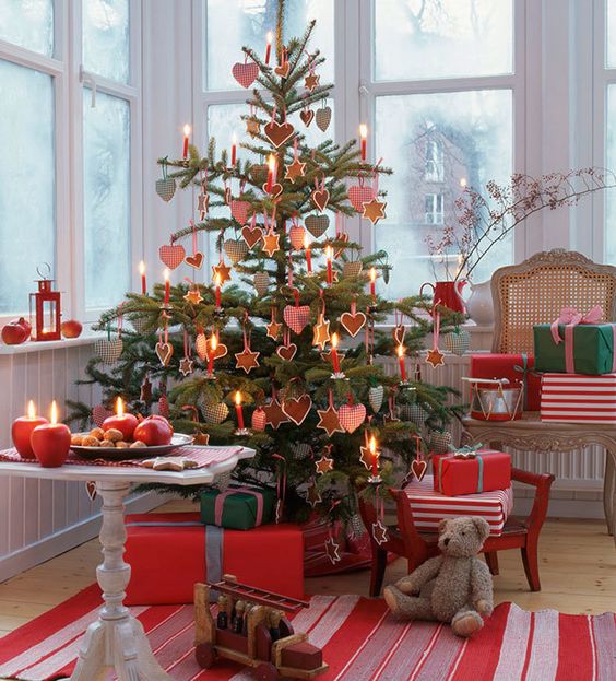 a traditional Scandi Christmas tree decorated with cookies and with printed gingham ornaments plus red candles is a great idea