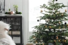 07 a Christmas tree with black, silver and gold ornaments and gold star topper and lights is modern and chic elegance