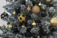 09 a flocked Christmas tree decorated with gold and black ornaments, babules and stars is a very chic and bold idea