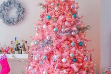 10 a candy pink Christmas tree with neutral, metallic and blue ornaments and lights looks very sweet and very cute