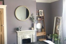 10 a small yet cozy bedroom with lavender walls, a refined built-in fireplace, a mini stained wood shelving unit and a round mirror