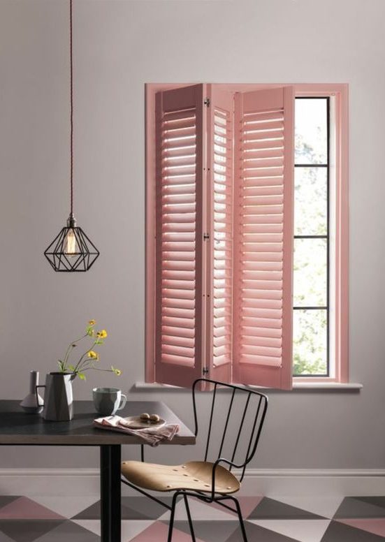 a pink shutter screen is a creative idea to add some color to the space and it echoes with the gemetric floor