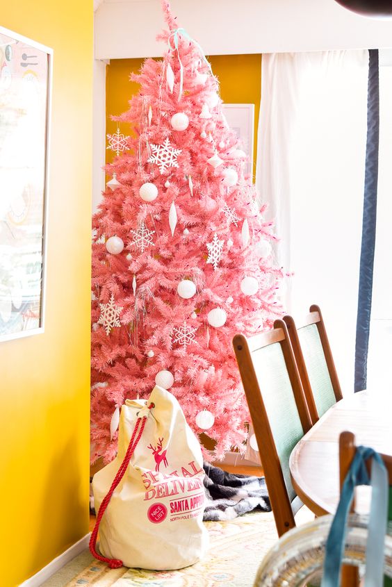 a delicate pink Christmas tree decorated with white ornaments of various looks is a tasteful and very girlish choice