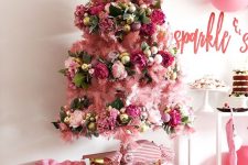 13 a girlish pink Christmas tree decorated with pink and gold ornaments, with pink faux blooms and leaves plus a gold star on top
