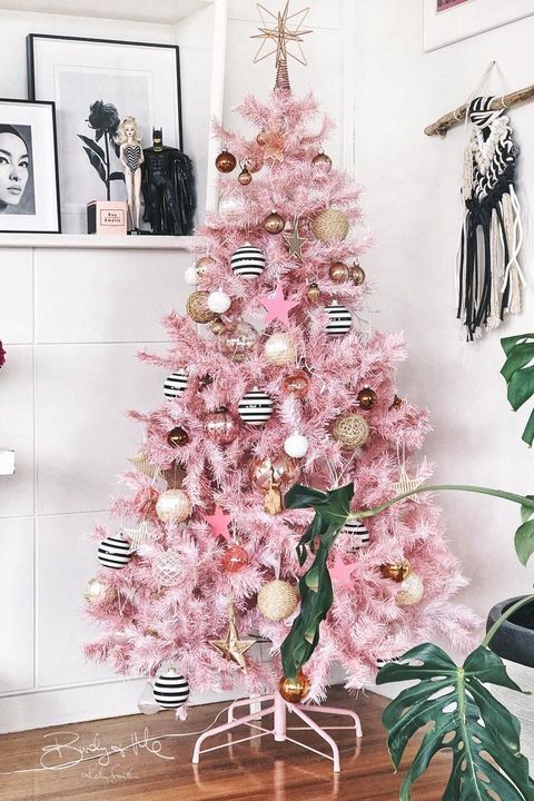 a glam pink Christmas tree with white, gold, gold glitter and striped ornaments plus a star on top is a very pretty and stylish idea