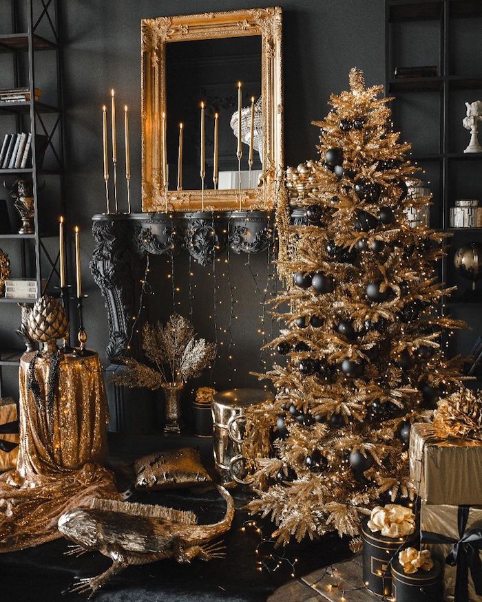 jaw dropping holiday black and gold decor with a faux mantel, a gilded frame and candles, a gold Christmas tree with black ornaments and lots of lights