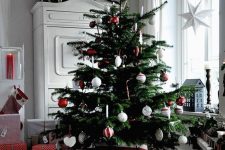 15 a classic Scandinavian Christmas tree with red and white ornaments, glass and felt ones is a lovely idea for every space