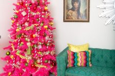 16 a hot pink Christmas tree with yellow and green ornaments, pompom garlands and fluffy banners is a very bold color statement that takes over the space