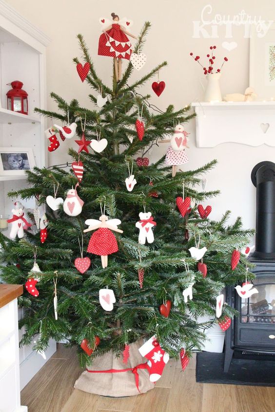 a fantastic traditional Scandinavian Christmas tree with red and white felt ornaments of various shapes and a simple burlap tree skirt