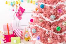 17 a pastel pink Christmas tree with colorful paper and glass Christmas ornaments and white garlands is a colorful modern solution