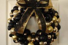 21 a beautiful black and gold Christmas wreath fully made of ornaments, with matching glitter bows is a gorgeous idea