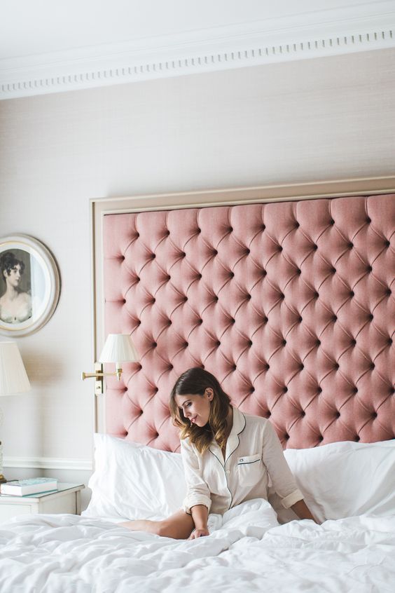a glam pink upholstered oversized headboard with a gold frame is a chic idea with a girlish feel
