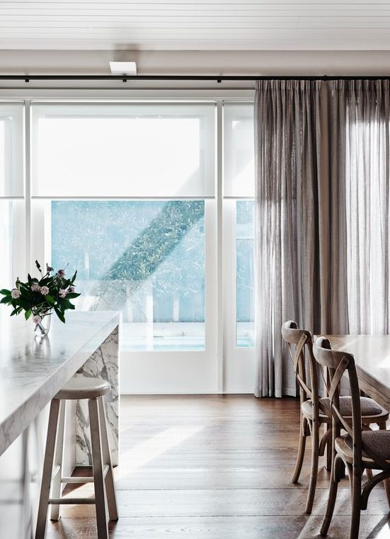 neutral roller shades look very well with curtains of any color and texture blocking excessive light (these are perfect as kitchen window treatments)