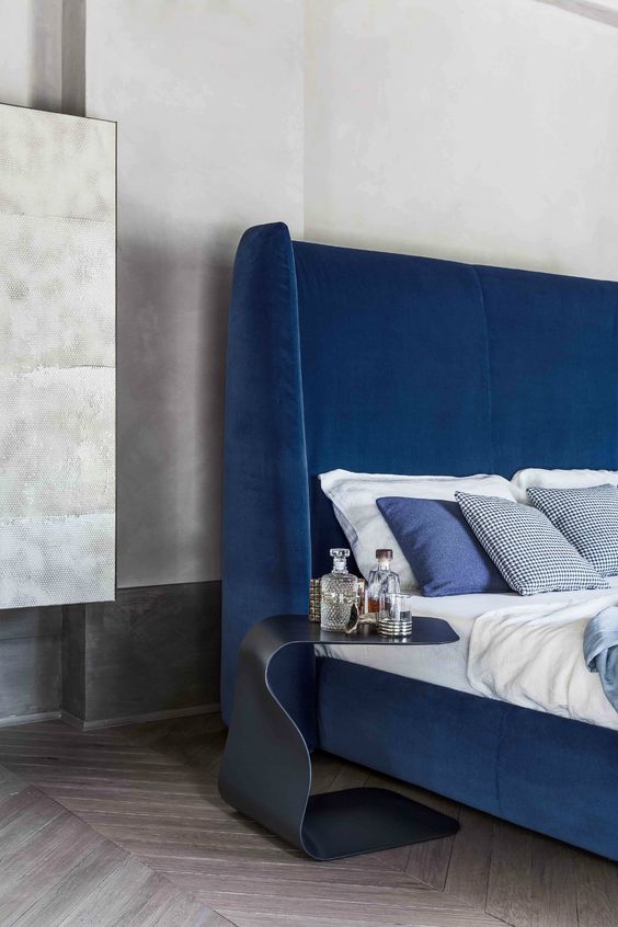 a modern electric blue upholstered bed that features a matching statement wingback headboard is a fantastic solution for a modern bedroom