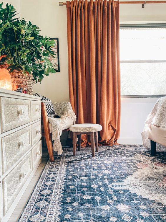 lovely heavy rust-colored curtains bring a touch of bold color and interest to the space and make the bedroom wow