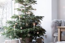 25 a delicate modern Scandinavian Christmas tree in a basket, with a bit of gold ornaments and some candles is a chic idea to rock
