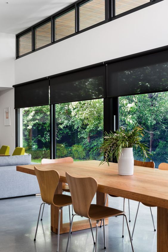 a stylish contrasting modern space with clerestory windows and a glazed wall treated with sleek black semi sheer blinds