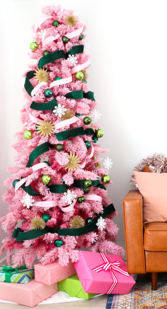 an elegant pink Christmas tree with green and gold ornaments, a pink and green velvet ribbon is a chic and bold solution with impeccable taste