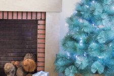 28 a beautiful modern turquoise Christmas tree with blue lights in a basket is a gorgeous solution, it requires no ornaments as it stands out itself
