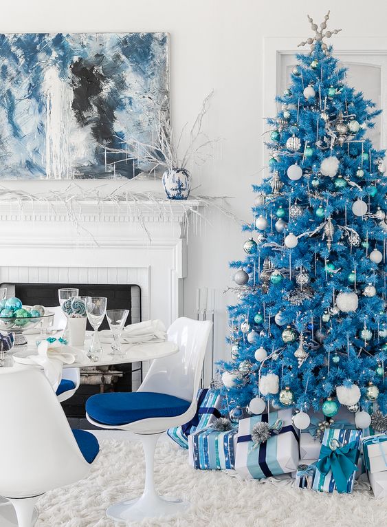 a blue Christmas tree with white and silver ornaments, lights, garlands and gifts in matching boxes under the tree