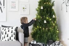 29 a modern Nordic tree with lights and white tree-shaped ornaments plus himmeli ones and black and white printed wrapped gifts is a lovely idea for a modern space