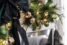 31 lovely festive decor with an evergreen and gold bell garland, black plaid ribbon bows, twigs and lights is great for Christmas