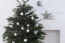 32 a modern Scandinavian Christmas tree with white ball and star ornaments in a basket looks very laconic and chic