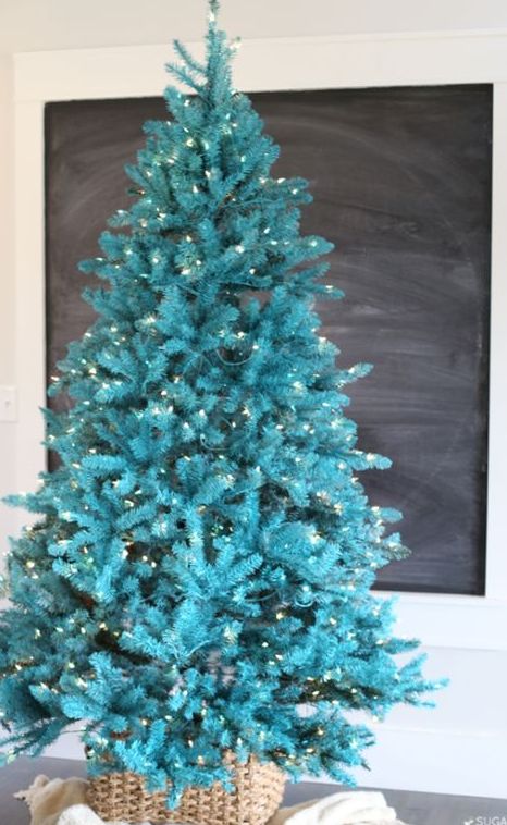 a gorgeous bold turquoise Christmas tree with lights in a basket   you don't need any decor as you alreayd have a bold color statement