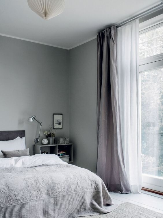a grey bedroom accented with sheer white curtains and with thicker lavender ones for a delicate touch of color