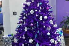 36 a bright purple Christmas tree with purple, silver, blue and white ornaments and snowflakes is a bold color statement that wows