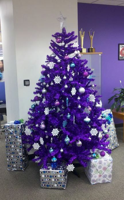 a bright purple Christmas tree with purple, silver, blue and white ornaments and snowflakes is a bold color statement that wows