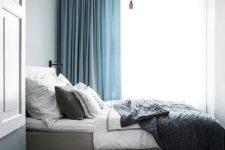 36 semi sheer white and thick blue curtains attached to the ceiling make this small bedroom look higher
