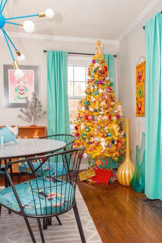 a mellow yellow Christmas tree with pink, green, red ornaments of vintage style is a super bold decor solution