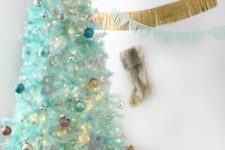 39 a modern mint-colored Christmas tree with blue, mint, pastel ornaments, lights and a silver glitter star on top is very tender and chic