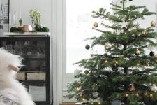 a Christmas tree with black, silver and gold ornaments and gold star topper and lights is modern and chic elegance