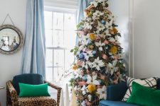 a Christmas tree with large white fabric blooms, blue ornaments, mustard fluffs, copper ribbons and a gold star topper is a cool and bright idea