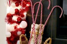 a basket with firewood and giant candy canes plus a red and white Christmas ornament garland for fun styling your space for Christmas