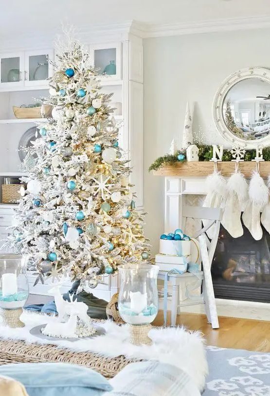 a beach Christmas space with a flocked Christmas tree, light blue and silver ornaments, starfish, an evergreen garland, blues and blue ornaments
