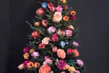 a beautiful and colorful Christmas tree decorated with faux blooms all the shades possible is a cool out of the box idea